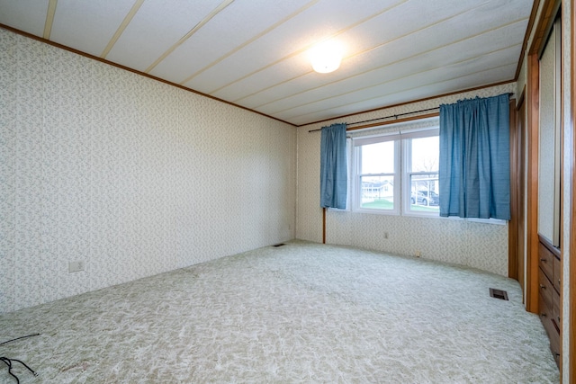 unfurnished room with visible vents, wallpapered walls, and carpet flooring