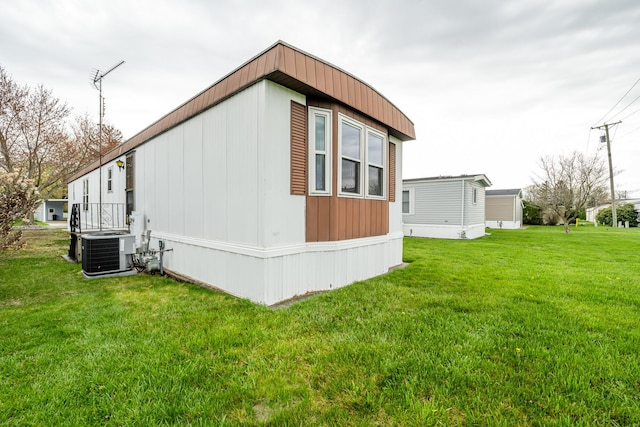 view of side of property featuring a lawn and central air condition unit