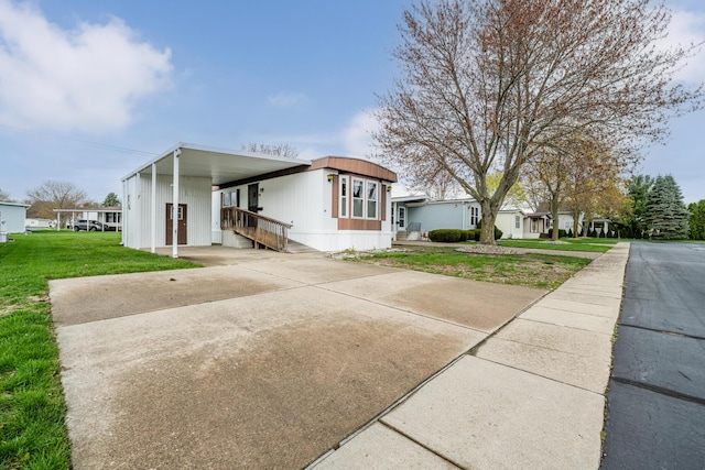 view of front of property with a front yard, driveway, and an attached carport