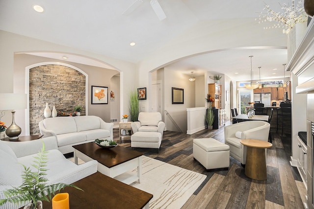 living area with recessed lighting, arched walkways, dark wood-style flooring, and lofted ceiling