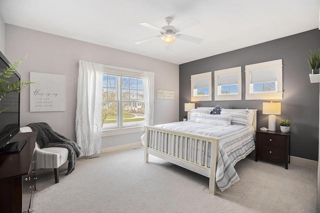 carpeted bedroom featuring baseboards and ceiling fan