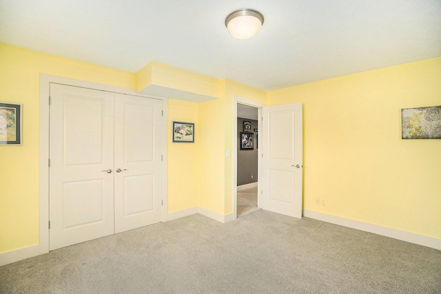unfurnished bedroom featuring a closet, carpet floors, and baseboards