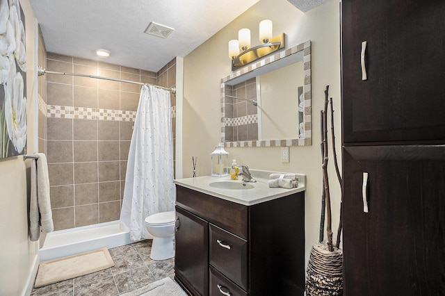 full bath with toilet, visible vents, vanity, and a tile shower