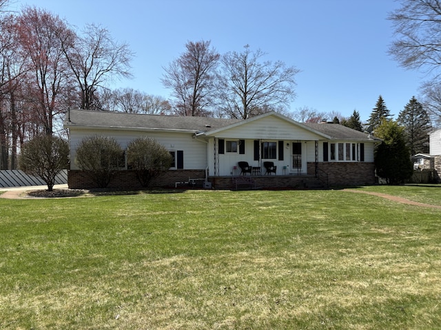 view of front of property with a front yard, covered porch, and brick siding