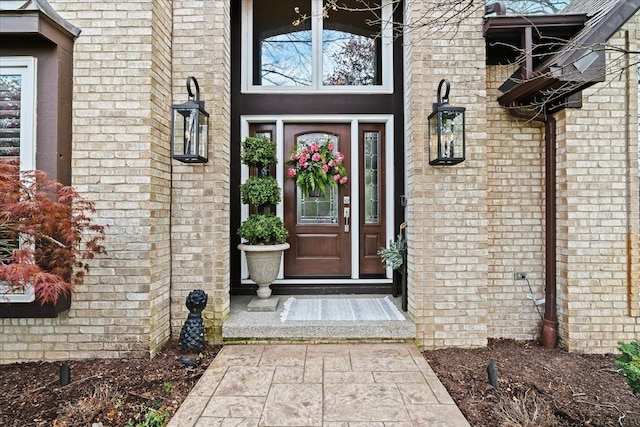 view of exterior entry with brick siding