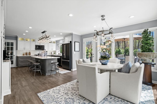 dining space with a chandelier, crown molding, recessed lighting, and dark wood finished floors