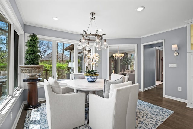 dining space featuring a chandelier, plenty of natural light, wood finished floors, baseboards, and crown molding