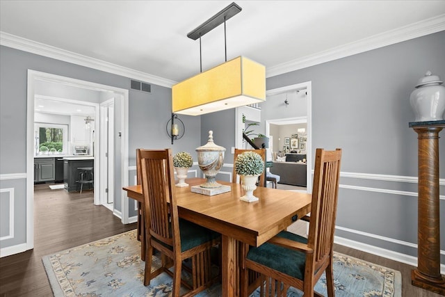 dining space featuring crown molding, dark wood-style floors, and baseboards
