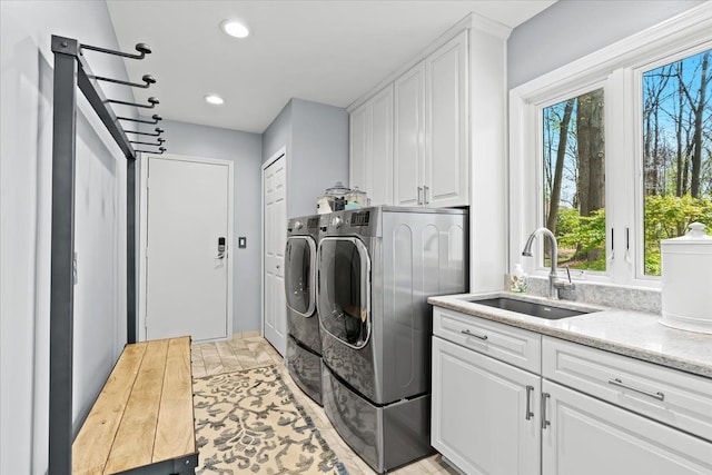 clothes washing area featuring washer and dryer, healthy amount of natural light, cabinet space, and recessed lighting