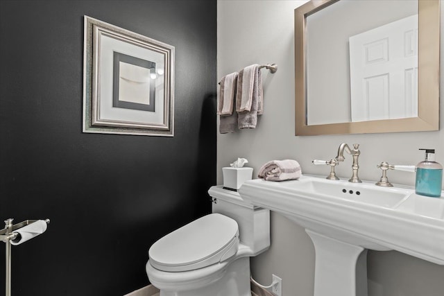 half bath with toilet and a sink