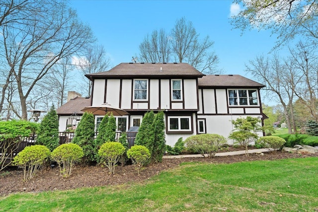 rear view of property featuring a yard and a chimney