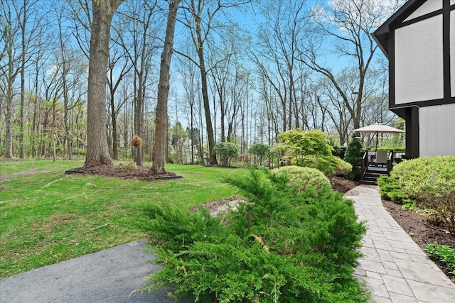 view of green lawn featuring a deck