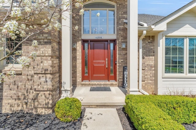 doorway to property with brick siding