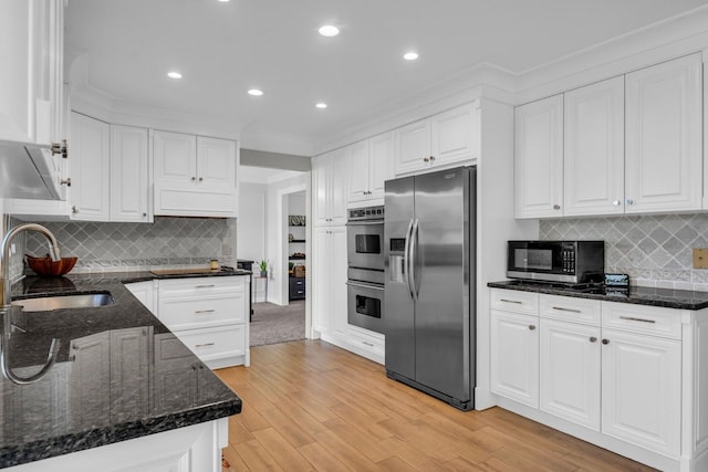 kitchen featuring a sink, light wood-style floors, ornamental molding, white cabinets, and appliances with stainless steel finishes