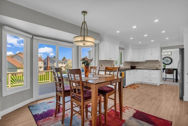 dining room with recessed lighting, baseboards, a wealth of natural light, and light wood-type flooring