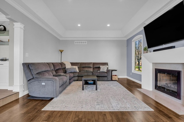 living area with baseboards, visible vents, a fireplace with flush hearth, and dark wood finished floors