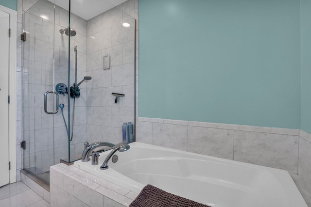 bathroom with a stall shower and a garden tub