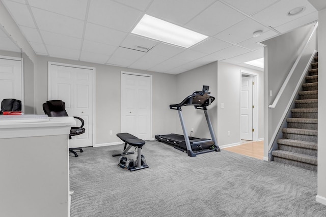 exercise area featuring baseboards, visible vents, carpet, and a drop ceiling