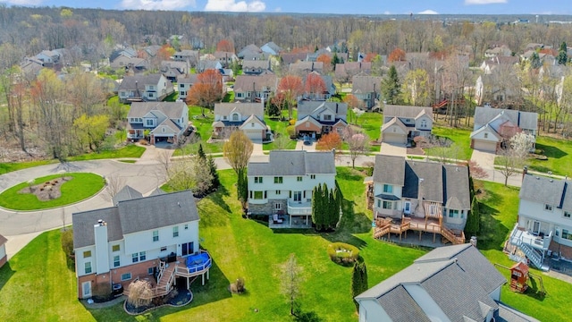 drone / aerial view featuring a wooded view and a residential view
