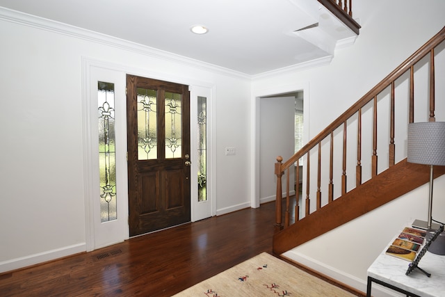 foyer entrance with stairs, baseboards, wood finished floors, visible vents, and ornamental molding