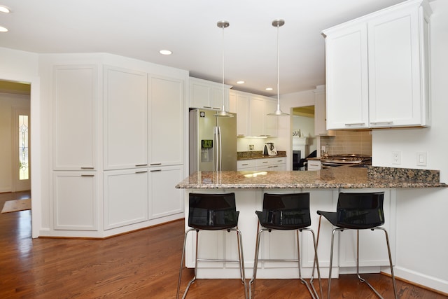 kitchen featuring white cabinets, stainless steel appliances, dark wood-type flooring, and a peninsula