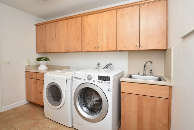 washroom featuring a sink, baseboards, cabinet space, and washer and clothes dryer