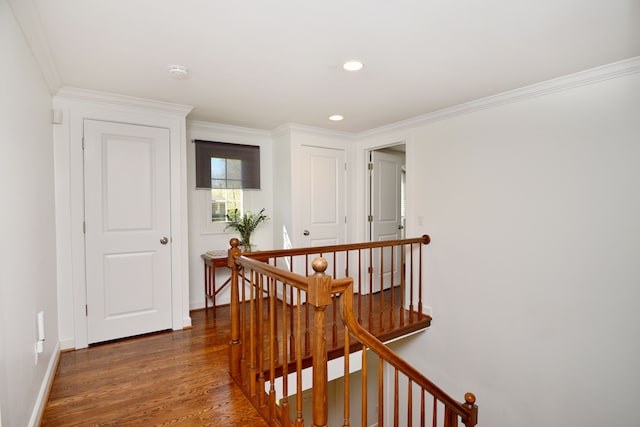 hall with ornamental molding, wood finished floors, baseboards, recessed lighting, and an upstairs landing