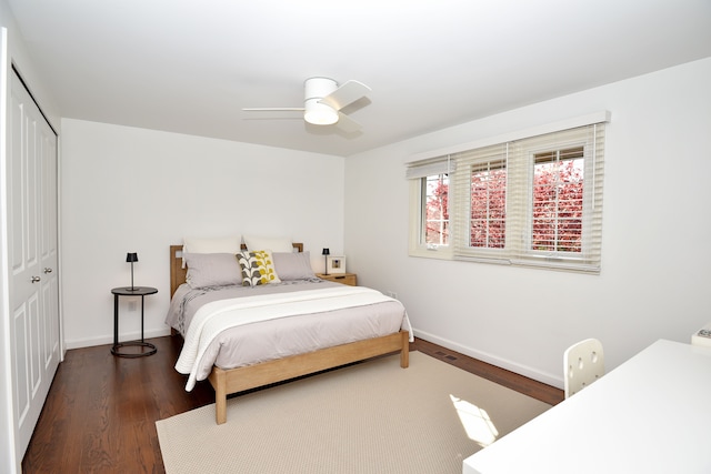 bedroom with a ceiling fan, baseboards, wood finished floors, and a closet