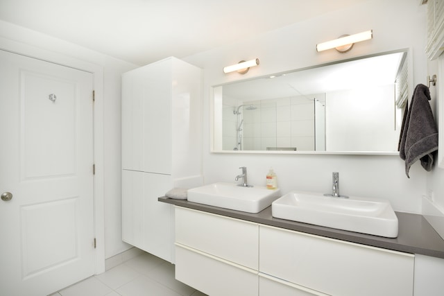 full bathroom featuring double vanity, tile patterned floors, a sink, and a shower