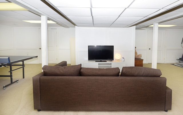 living room with carpet flooring and a paneled ceiling