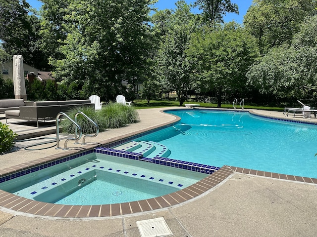 view of pool featuring a pool with connected hot tub and a patio area