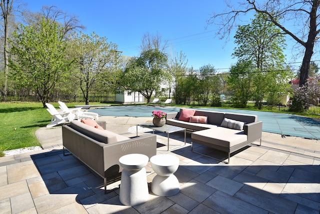 view of patio with fence, a shed, outdoor lounge area, a fenced in pool, and an outdoor structure