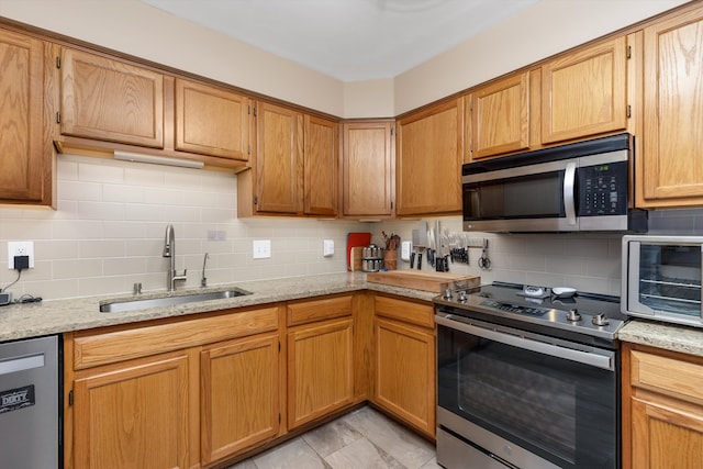 61161 Greenwood Dr, South Lyon, MI 48178 - kitchen with light stone counters, a sink, appliances with stainless steel finishes, and tasteful backsplash