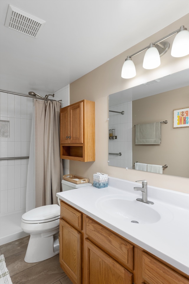 61161 Greenwood Dr, South Lyon, MI 48178 - full bathroom featuring visible vents, vanity, wood finished floors, toilet, and a tile shower