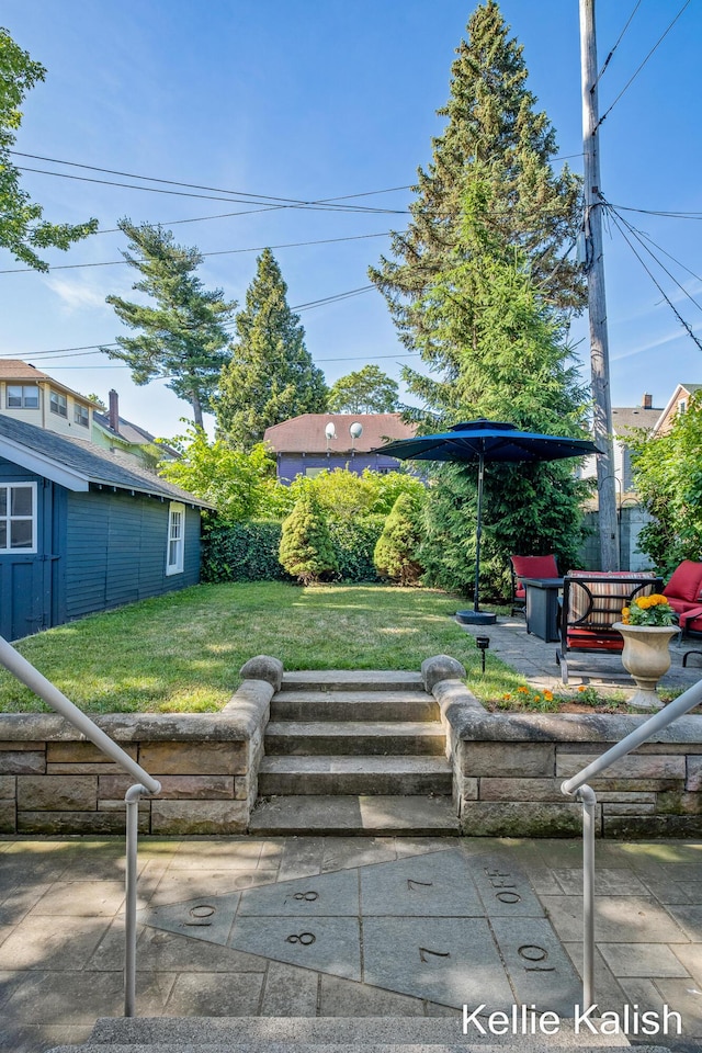 548 Pleasant St SE, Grand Rapids, MI 49503 - view of grassy yard featuring a patio and an outbuilding