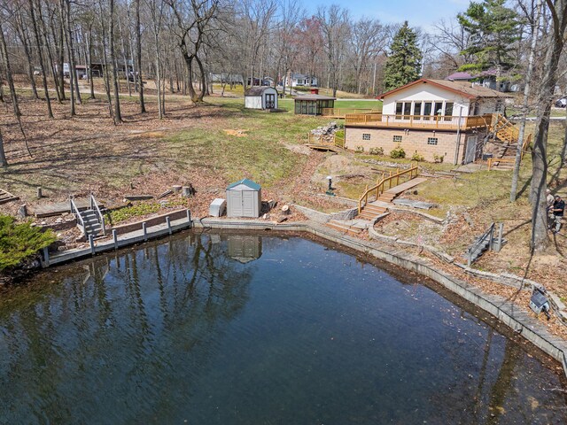 dock area featuring stairway and a deck with water view