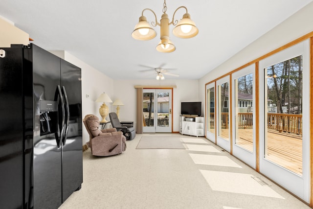 living room with ceiling fan with notable chandelier and a healthy amount of sunlight