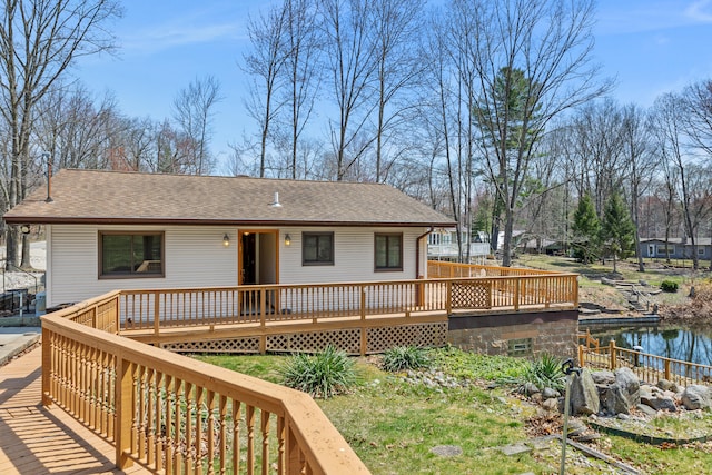 exterior space featuring a wooden deck and a shingled roof