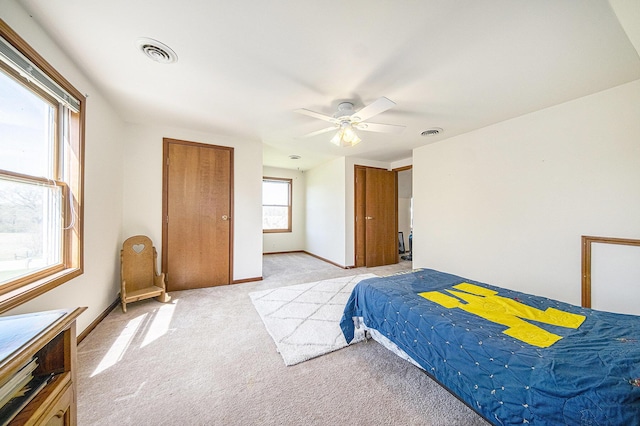 bedroom with visible vents, ceiling fan, light carpet, and baseboards