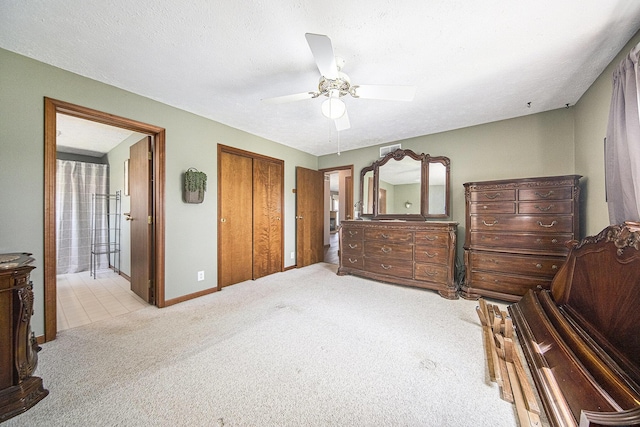 carpeted bedroom with baseboards, visible vents, ceiling fan, and connected bathroom