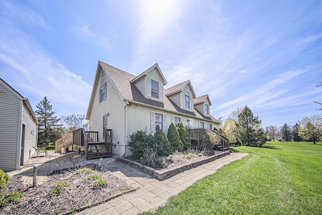 view of side of property featuring a lawn, a wooden deck, stairway, and a shingled roof