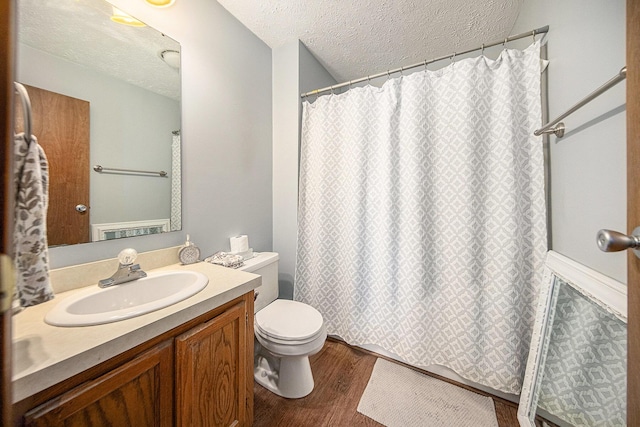 bathroom featuring vanity, curtained shower, toilet, a textured ceiling, and wood finished floors