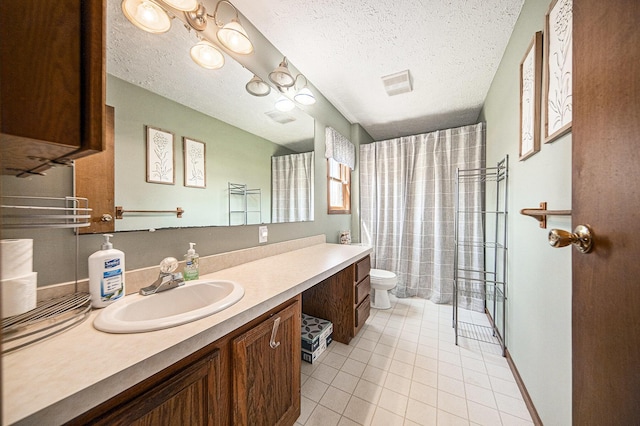 full bath featuring vanity, tile patterned floors, toilet, visible vents, and a textured ceiling