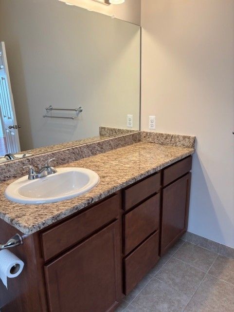 bathroom with vanity, baseboards, and tile patterned floors
