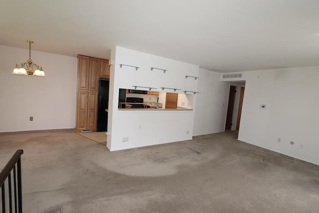 1196 Leisure Dr, Flint, MI 48507 - unfurnished living room featuring visible vents, light carpet, and an inviting chandelier