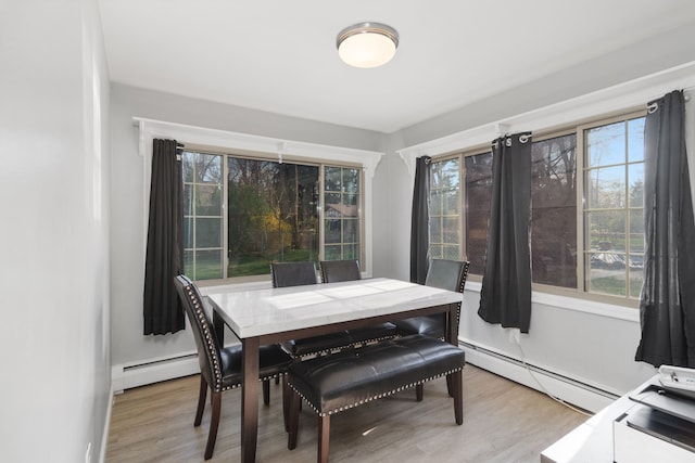 dining area featuring a baseboard radiator and light wood-style flooring