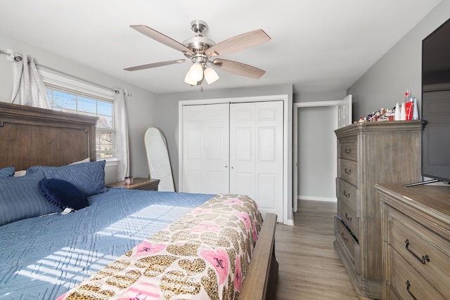 bedroom featuring light wood-style floors, baseboards, ceiling fan, and a closet