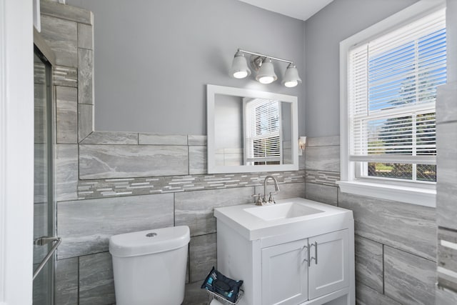 bathroom featuring toilet, tile walls, and plenty of natural light