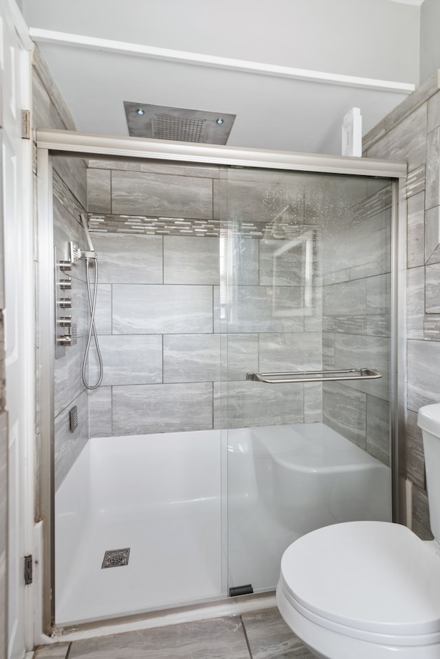 bathroom featuring a shower stall and toilet