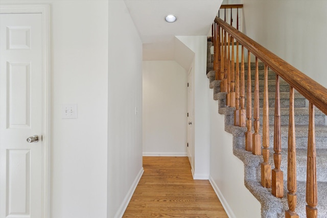 stairway featuring baseboards and wood finished floors